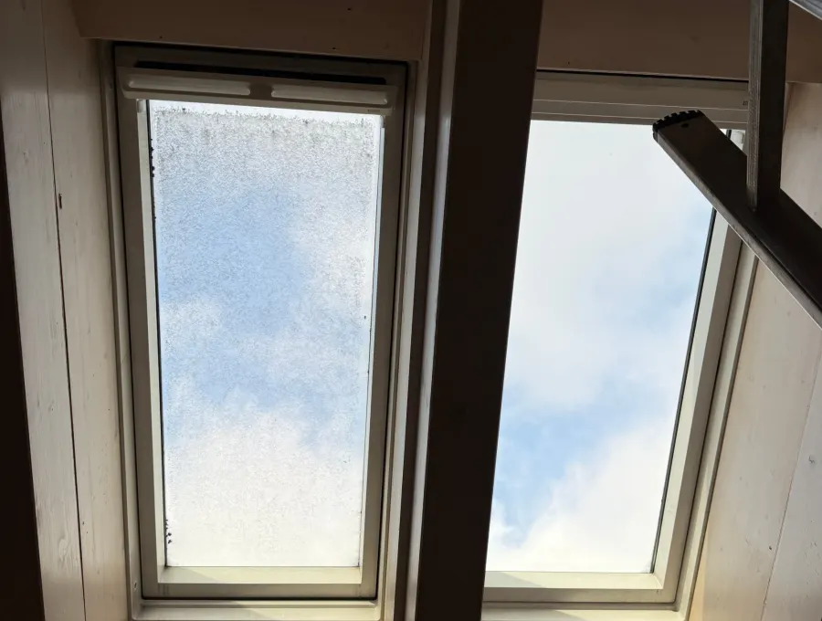 Zwei Dachfenster nebeneinander, links verschmutzt, rechts gereinigt